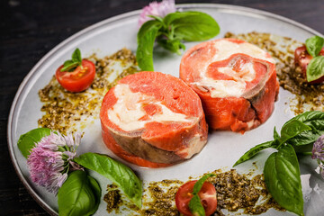 Close-up pink salmon roll with cream cheese and shrimp meat with ricotta pesto sauce with fresh basil. Delicious seafood restaurant dishes