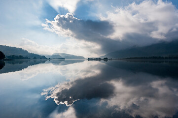 Obraz premium flat mirror like lake and dramatic clouds in the mountains