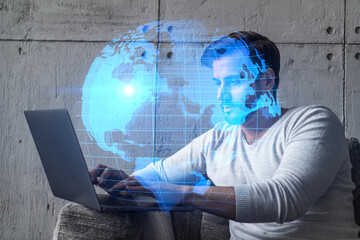 A serious caucasian manager in casual wears, using laptop to develop a new worldwide supply chain. Double exposure. globe and map hologram.