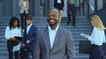 Portrait of joyful young african american start-up developer office executive businessman smiling outside corporate building. Business people. Employment. Occupation.