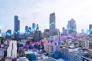 Forex and stock market chart hologram over panorama city view of Bangkok, the financial center in Asia. The concept of international trading. Double exposure.