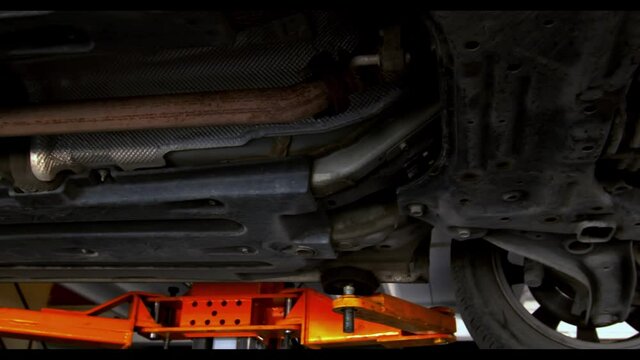 Bottom view of lifted car in the workshop