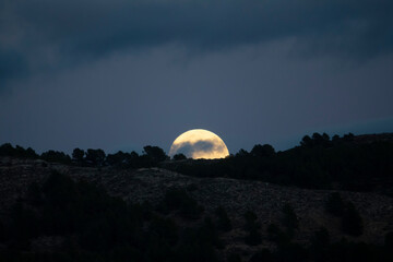 full moon rising on a mountain