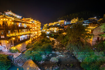 Fototapeta na wymiar Furong Ancient Town illuminated at night. Amazing beautiful landscape scene of Furong Ancient Town (Furong Zhen, Hibiscus Town), China