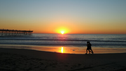 Fototapeta na wymiar silhouette of a man walking on the beach