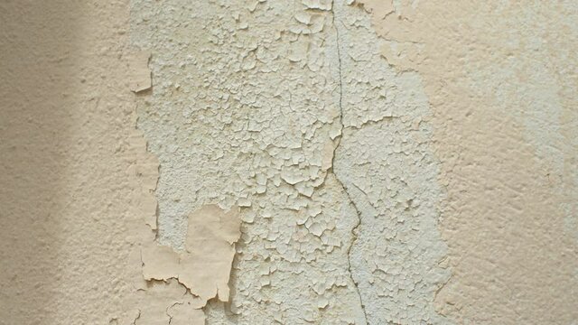 Patches of cracking paint on wall