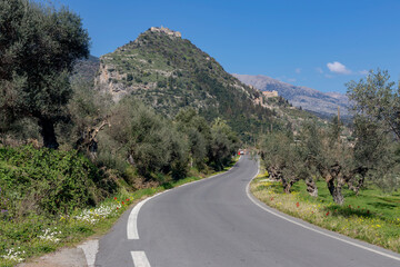 Street with stone houses in the village and view of the fortress on the mountain