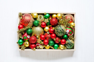 Festive Christmas accessories in a wooden tray on white wooden background