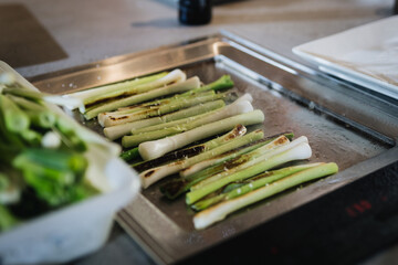 Detalle de esparr&aacute;gos sobre bandeja de metal en cocina