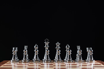 Silvery chess figures standing on chessboard