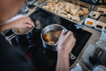 Manos friendo carne en cocina de vitro cerámica