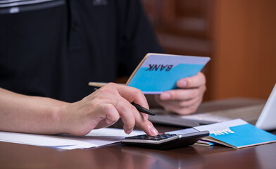 The hands of the men who are holding a bank passbook and weaving a budget.