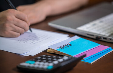 The hands of the men who are holding a bank passbook and weaving a budget.