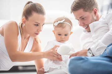 Young family plays with together lying on the floor at home