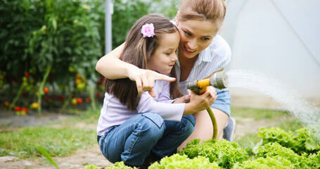 Beautiful happy mother and daughter working in the farm, garden