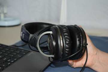 Obraz na płótnie Canvas headphones in hand in front of the computer