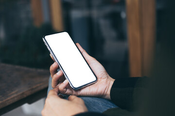 cell phone mockup image blank white screen.woman hand holding texting using mobile on desk at coffee shop.background empty space for advertise.work people contact marketing business,technology