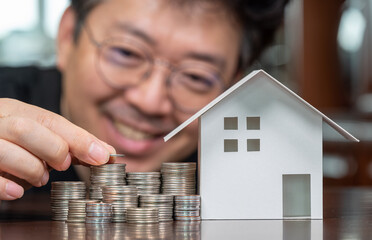 Model houses and stacked coins. Home equity loans. Mortgages and loans.