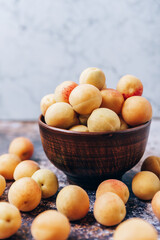 Lots of ripe yellow apricots close up in a crockery on the table
