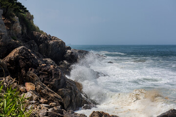 The big breaking waves during a strom at the beautiful summer sea shore background the blue sky and...