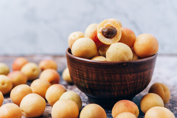 Lots of ripe yellow apricots close up in a crockery on the table