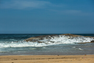 The big breaking waves during a strom at the beautiful summer sea shore background the blue sky and...