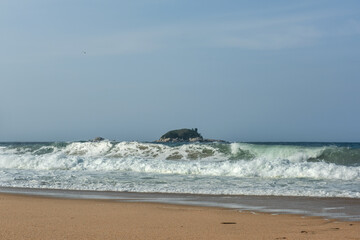 The big breaking waves during a strom at the beautiful summer sea shore background the blue sky and...