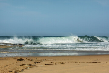The big breaking waves during a strom at the beautiful summer sea shore background the blue sky and...