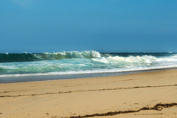 The big breaking waves during a strom at the beautiful summer sea shore background the blue sky and horizon