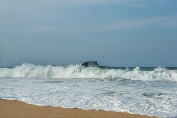 The big breaking waves during a strom at the beautiful summer sea shore background the blue sky and horizon