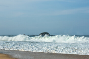 The big breaking waves during a strom at the beautiful summer sea shore background the blue sky and...