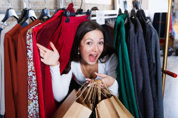 Positive cute girl customer delighted between the handles in the store.