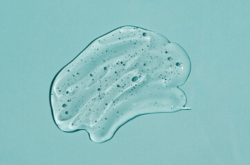 Transparent skin care product.Cosmetic clear liquid cream smudge. Liquid gel cosmetic on blue background.  