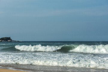 The big breaking waves during a strom at the beautiful summer sea shore background the blue sky and horizon