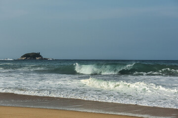 The big breaking waves during a strom at the beautiful summer sea shore background the blue sky and...