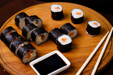 Sushi with salmon. Soy sauce, red caviar. Sushi on a black background.