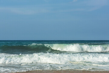 The big breaking waves during a strom at the beautiful summer sea shore background the blue sky and horizon