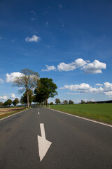 Landstraße mit Bäumen und Pfeil