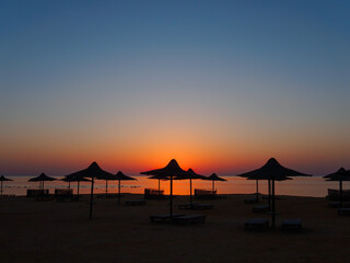 Beach umbrella  silhouette at sunrise, tropical sea landscape