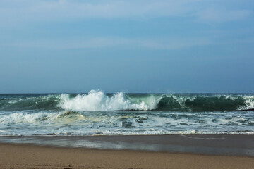 Fototapeta na wymiar The huge waves crashing into ston island against the blue sky and horizon at summer sea shore.