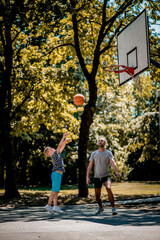 Cute blond boy practicing basketball with his coach