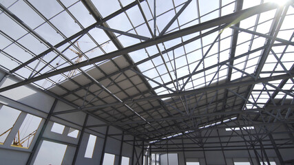 Construction of modern factory or warehouse, modern industrial exterior, panoramic view. Modern storehouse construction site, structural steel structure of new commercial building