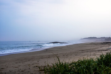 The huge waves crashing into ston island against the blue sky and horizon at summer sea shore.