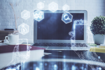 Fototapeta premium Computer on desktop in office with technology theme hologram. Double exposure. Tech concept.