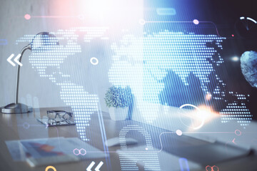 Double exposure of desktop with computer and world map hologram. International data network concept.
