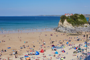 Fototapeta na wymiar Holidaymakers and sunbathers on Newquay beach in Cornwall