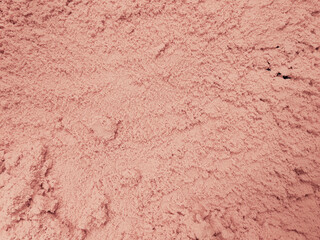 Texture of kinetic sand, pink beige color. Rough surface abstract background.