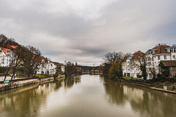 Fototapeta na wymiar View of the River Neckar with traditional German houses captured from the popular Eberhard Bridge. It reflects how the well off housing community is settled by the river banks - Tubingen, Germany