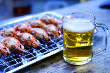 Grilled shrimp (Giant freshwater River prawn) grilling with charcoal at home, Natural Light in the evening with Beer. Bangkok, Thailand