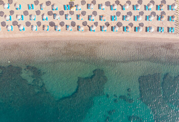 Aerial view of amazing tropical beach with white umbrellas and turquoise sea.  Top down aerial view beautiful beach